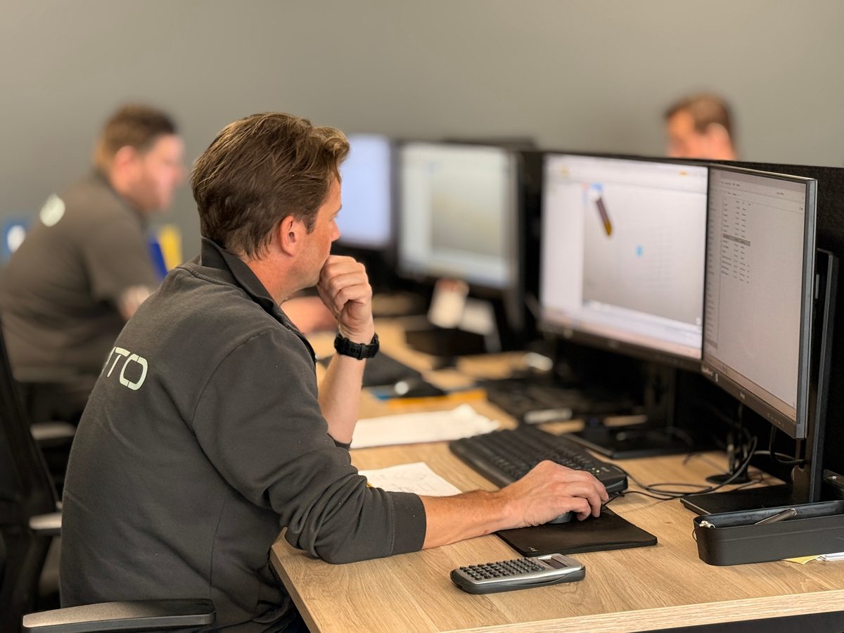 Programmeur aan het werk achter meerdere schermen